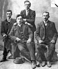 Крайній ліворуч — Йось Шуберт; тримає тростину Нусь Шуберт (?), крайній праворуч — Пінхос Бараш, ім’я чоловіка, який стоїть позаду, — невідоме. 1910-ті роки. З сімейного архіву Марка Бараша